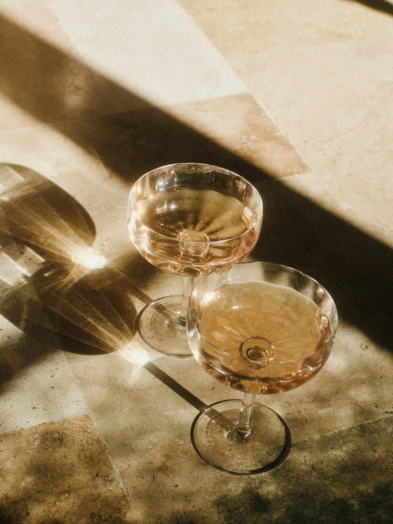 Two coupes of rosé in late afternoon light