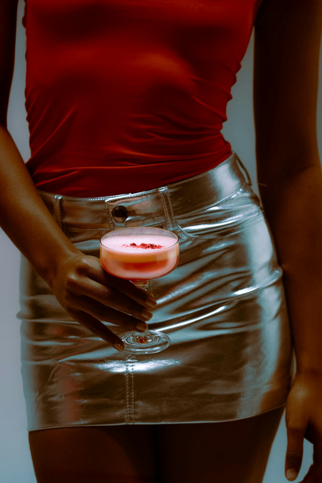 A woman in red holding a coupe of cherry foam